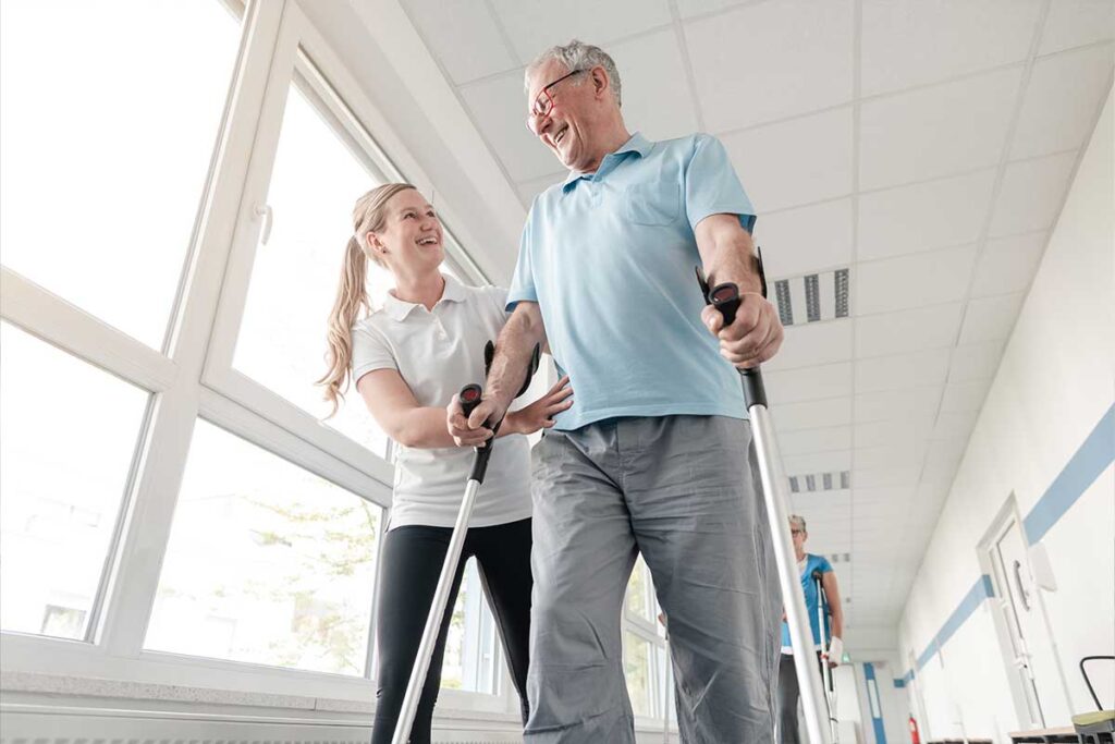 Man using walking aids and getting help from woman