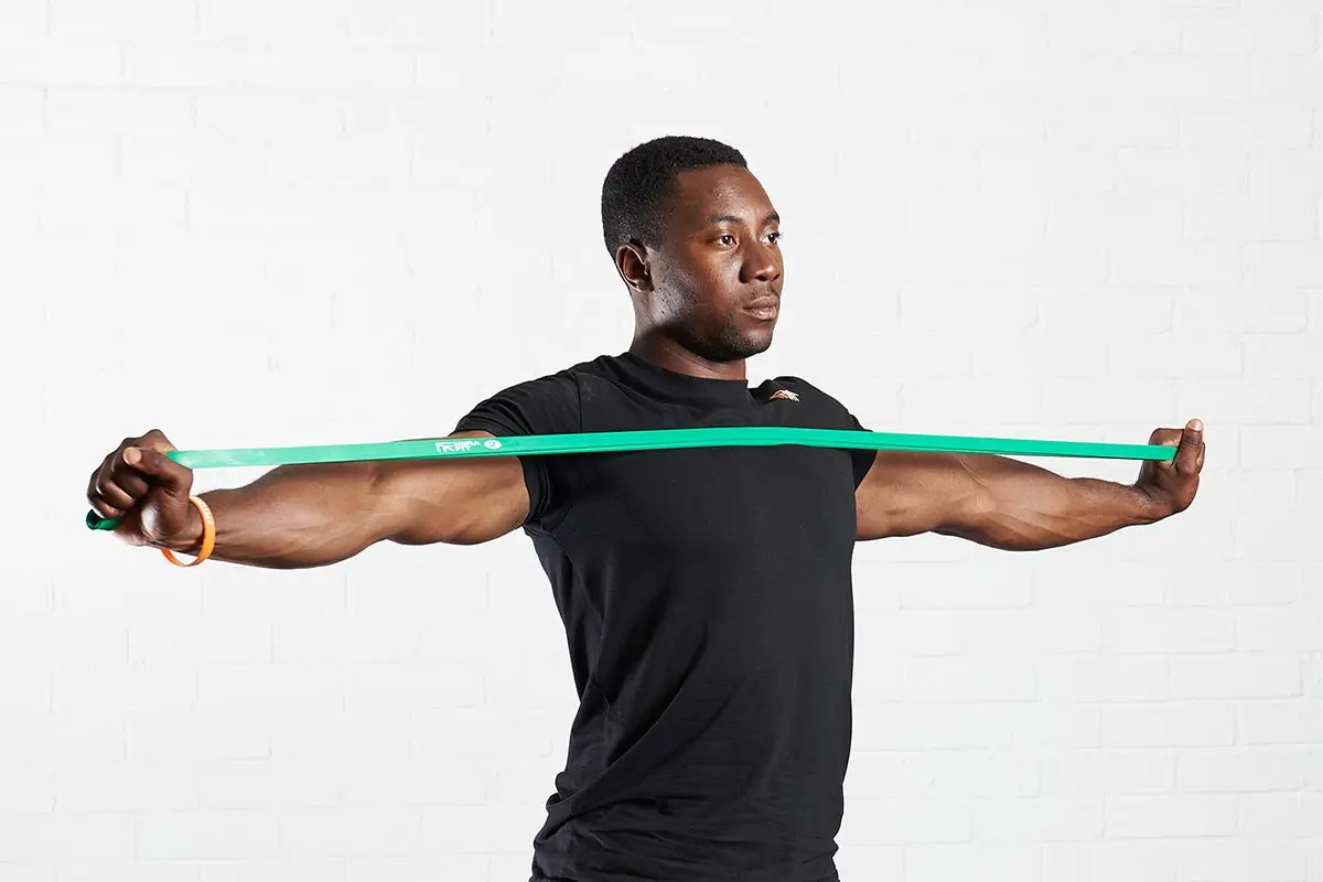 man-using-a-green-resistance-band-across-his-chest